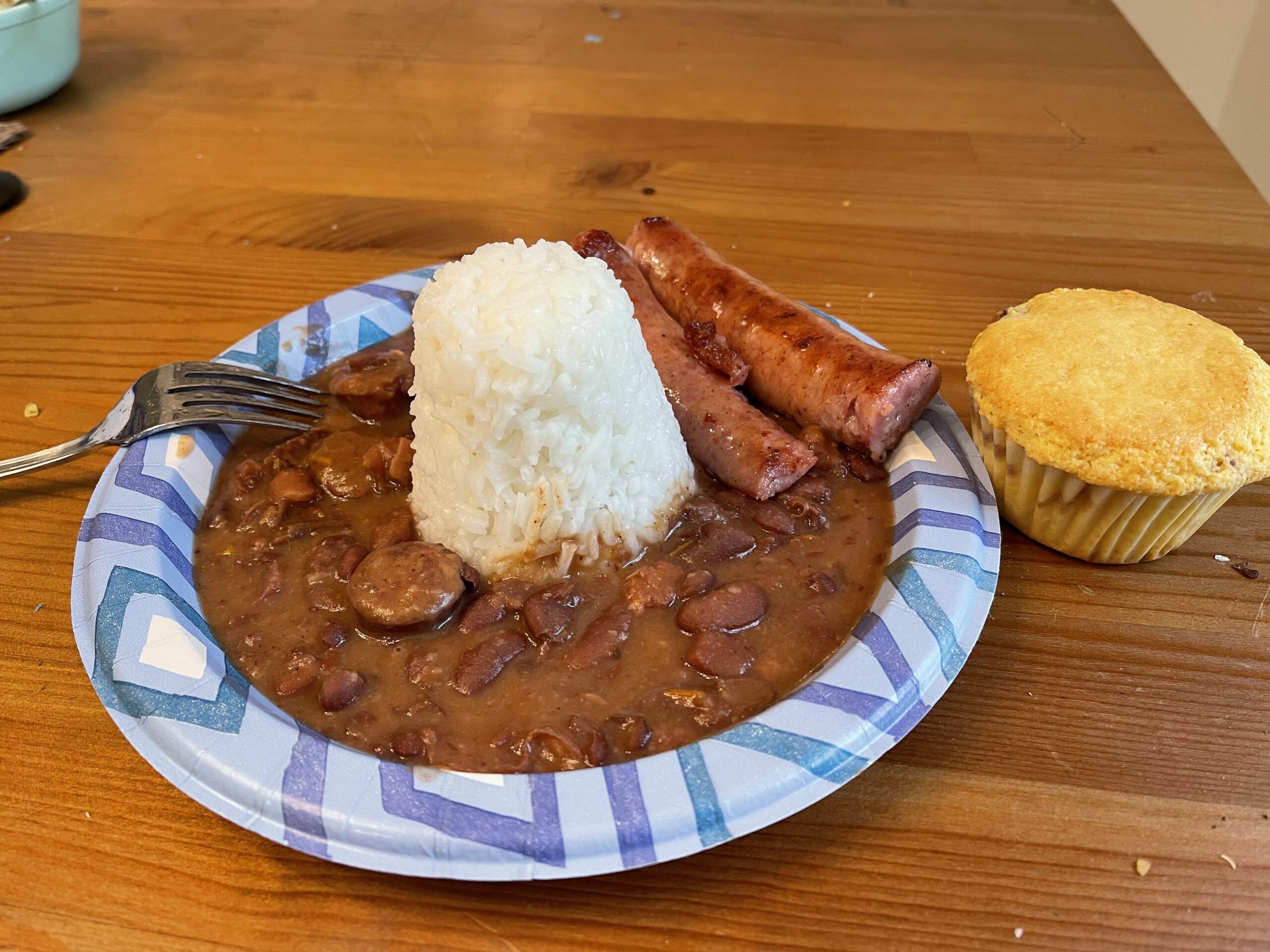 Red beans and rice, cornbread and smoked sausage on a paper plate